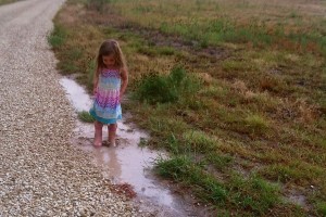 Young girl in puddle on farm